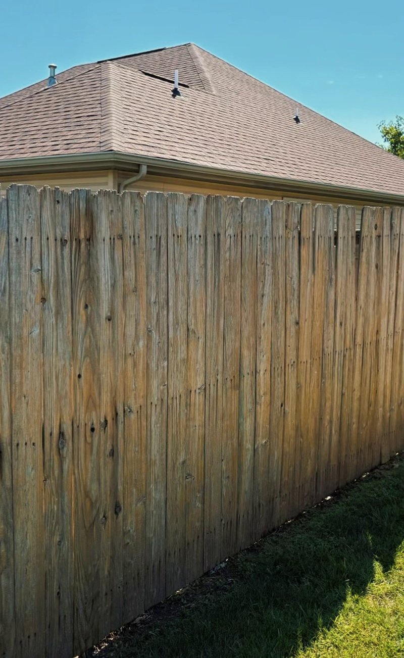 Close-up of weathered gray fence boards before staining